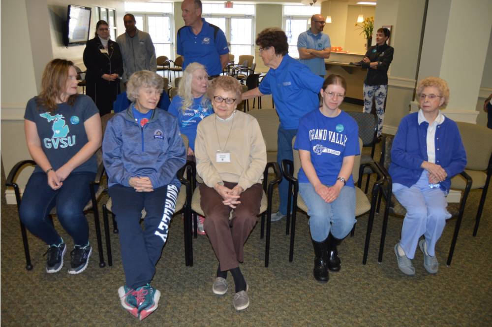 Volunteers and seniors sit together at the event.